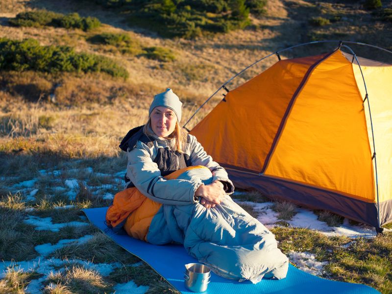 Randonneuse dans son sac de couchage à l'extérieur de sa tente