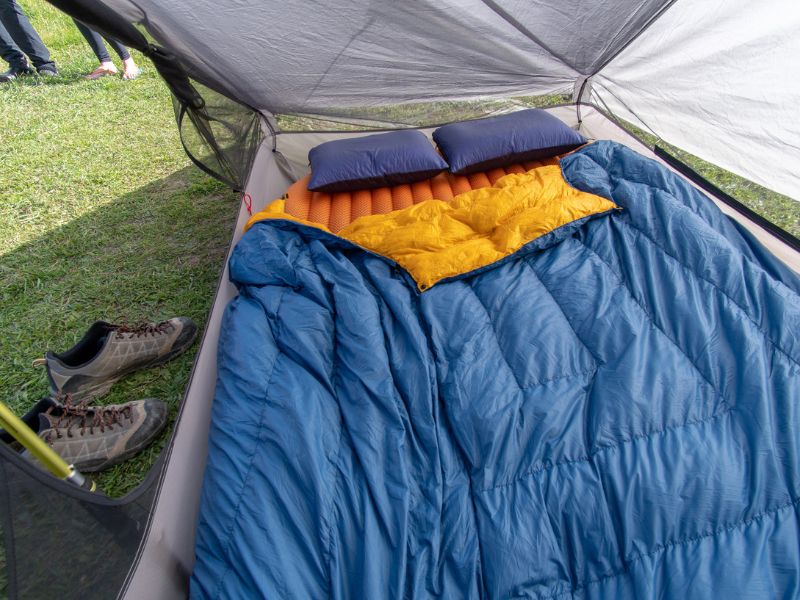 Intérieur d'une tente avec matelas, oreillers et sac de couchage
