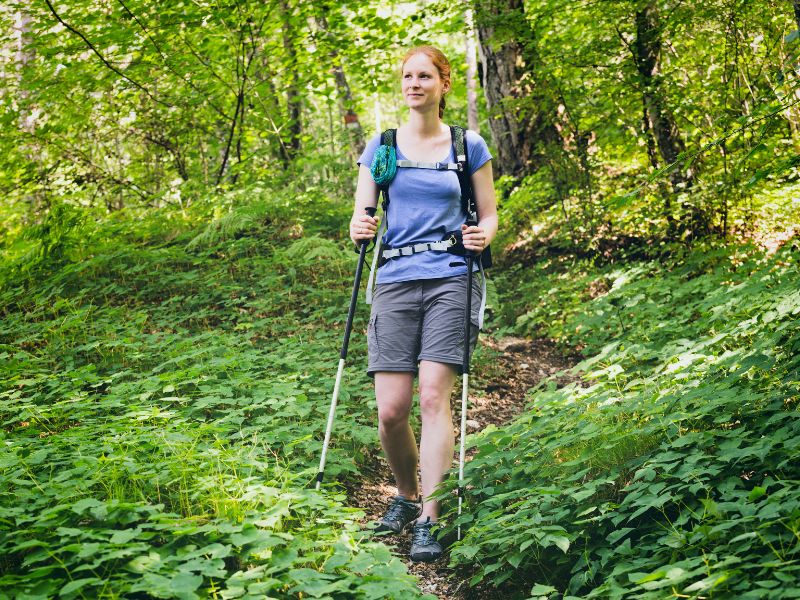 Femme qui marche seule dans les bois en randonnée